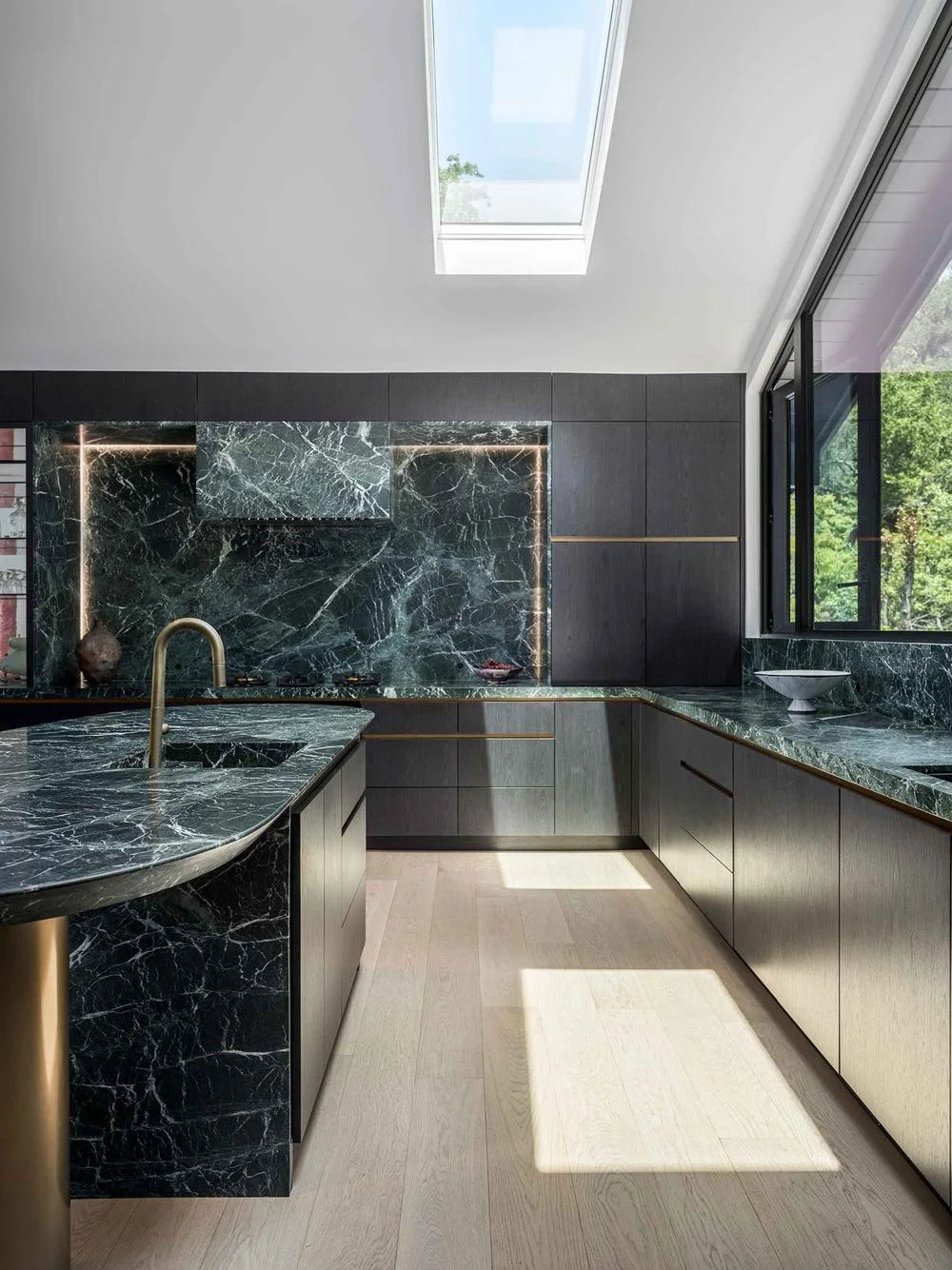 Sunlit modern kitchen with green stone counters and backsplash